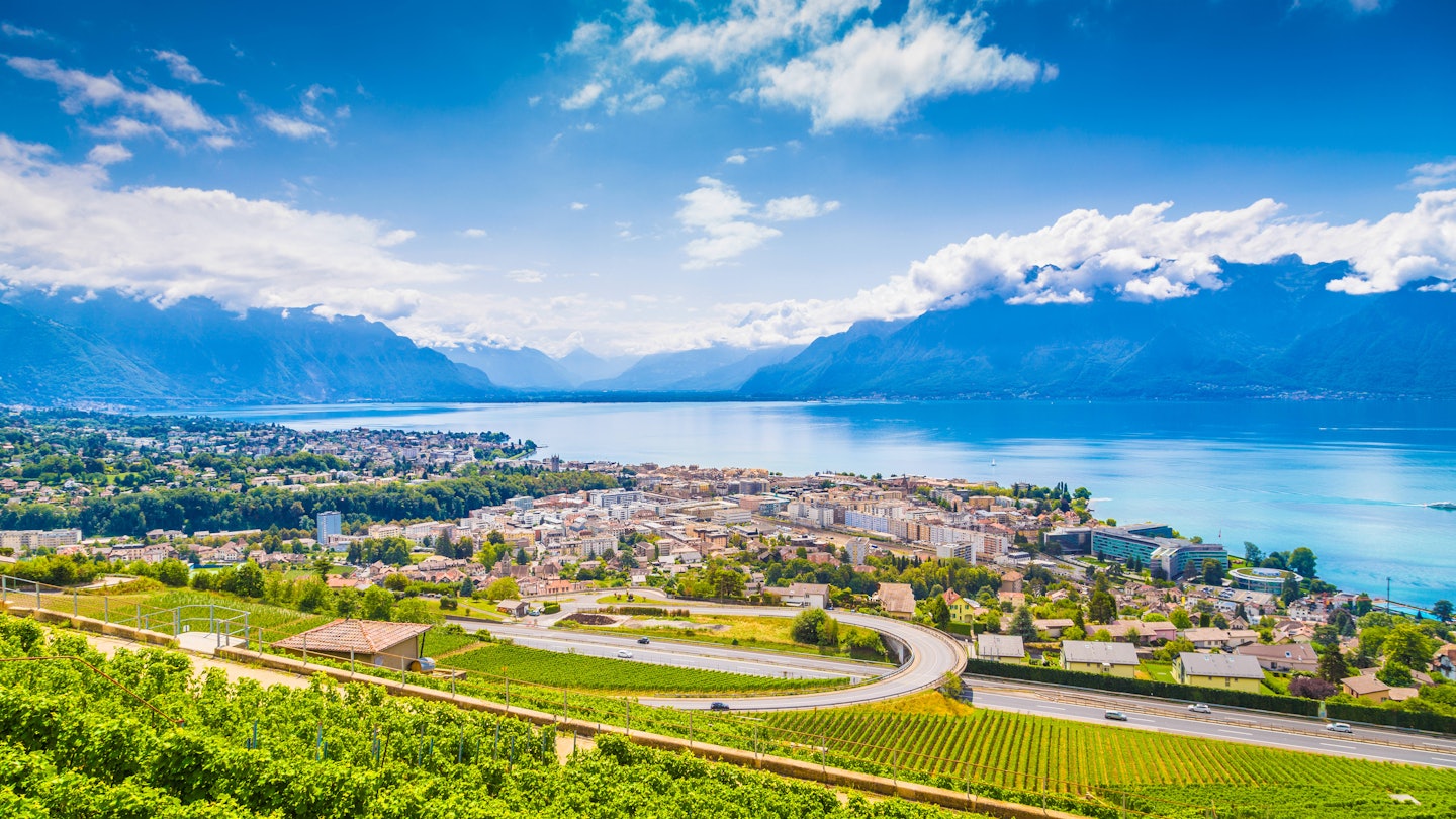 Aerial panoramic view of the city of Vevey at Lake Geneva with vineyards of famous Lavaux wine region on a beautiful sunny day in summer, Switzerland.