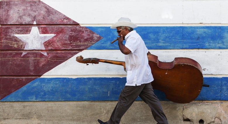 573064785
50-54 years, bass, carrying, cello, cigar, color image, Cuba, cuban flag, day, flag, full length, hat, horizontal, latin american and hispanic ethnicity, lifestyle, looking down, man, mature adult, mature men, motion, mural, music, musician, one person, outdoors, patriotism, people, photography, Santiago, Santiago de Cuba, side view, sidewalk, smoking, striped, sunglasses, travel, travel destinations, upright bass, urban, walking