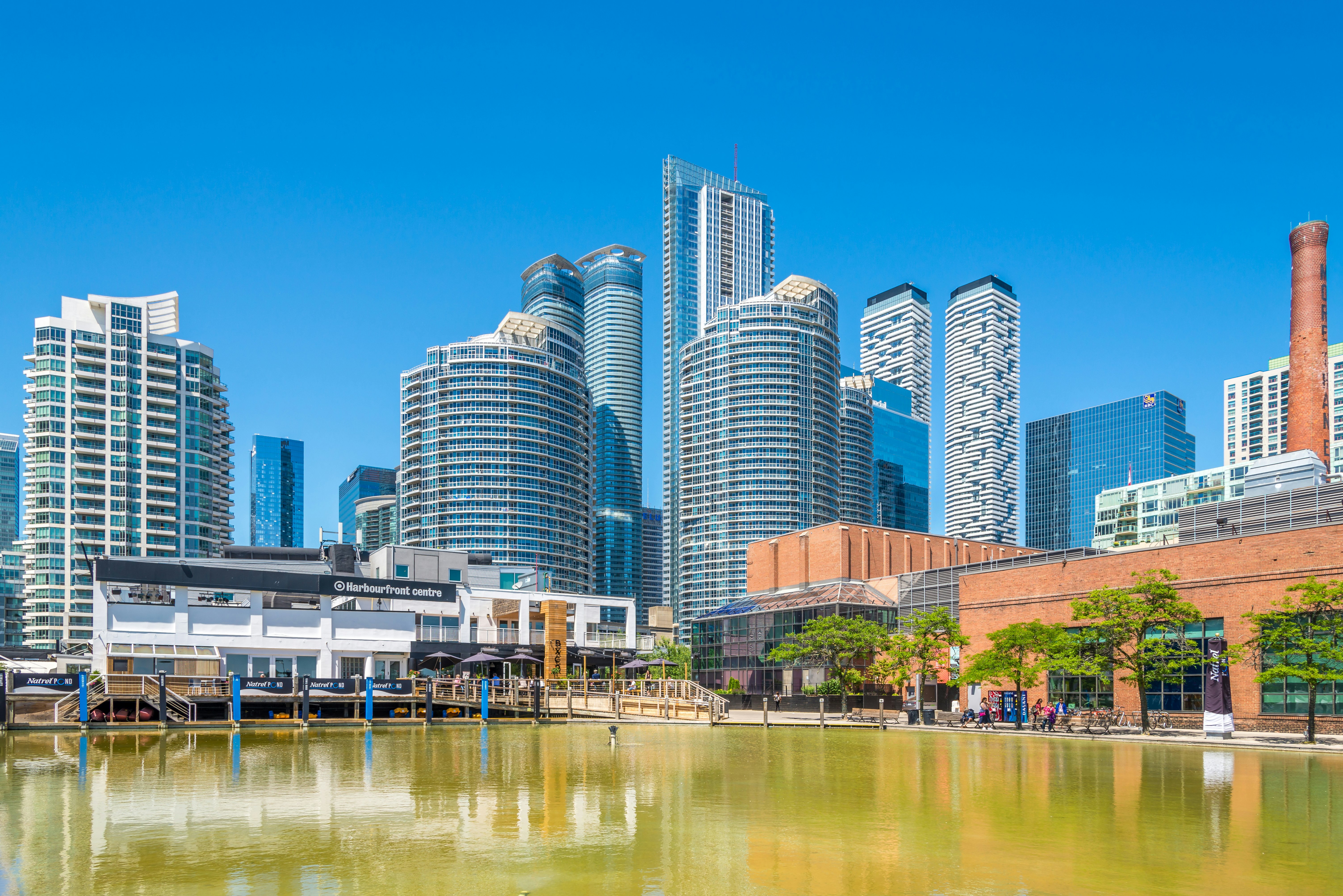A waterway lined with cultural buildings overlooked by skyscrapers