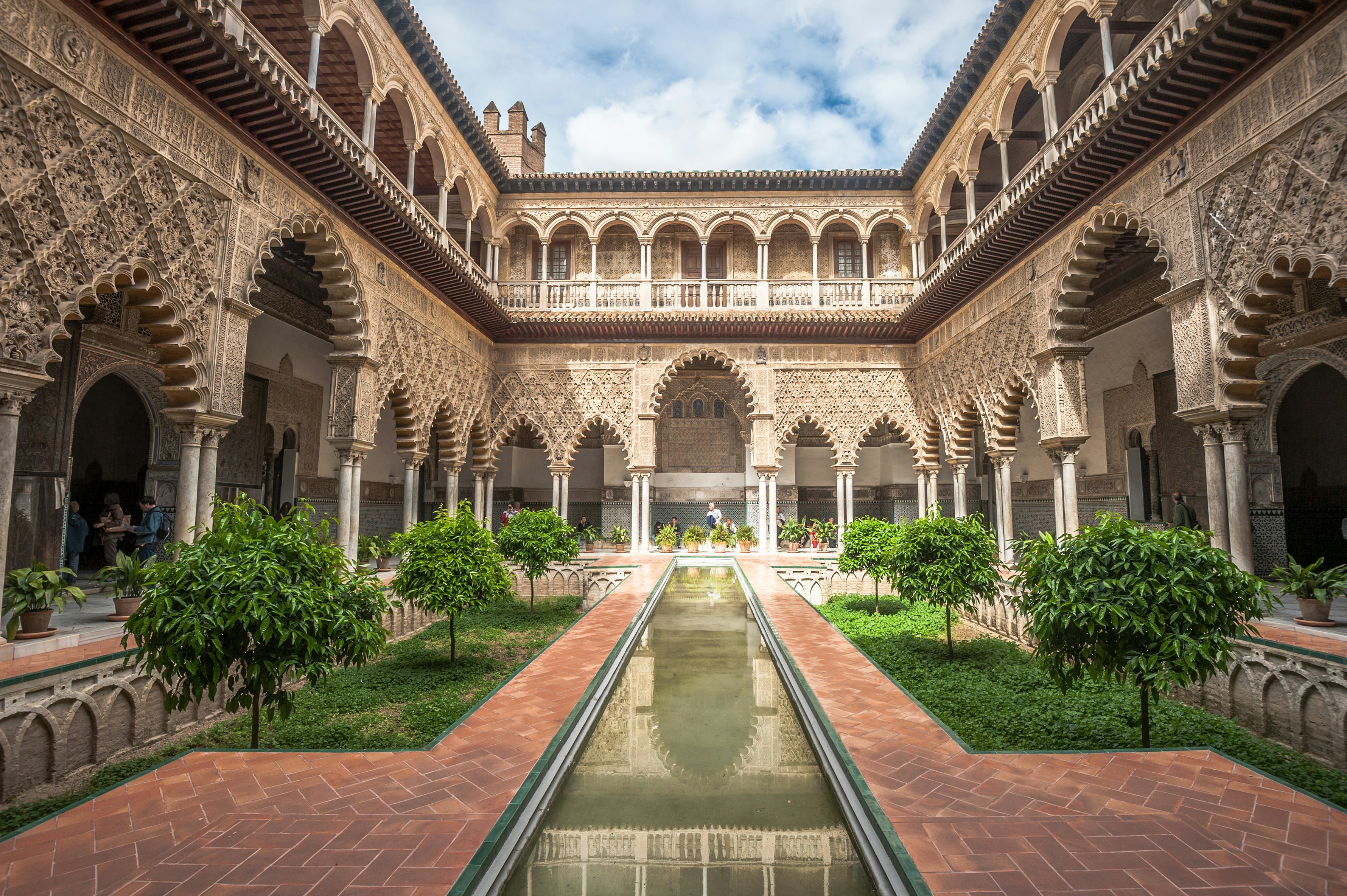 A courtyard within an ornate building, dominated by a small rectangular pond