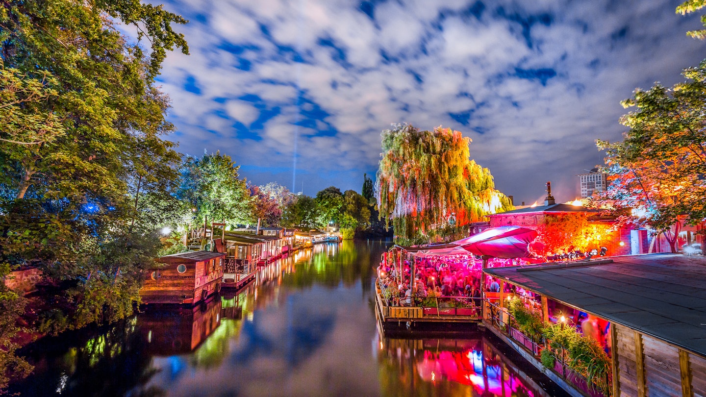 Panoramic view of young people partying in an open-air outdoor club at famous Flutgraben water canal on a beautiful warm summer night with moving clouds in Berlin Kreuzberg, Germany
627850778
alt-treptow, architecture, bar, berlin, blue, boat, bridge, canal, celebration, channel, city, club, clubbing, colorful, crowd, culture, dance, disco, dj, downtown, entertainment, europe, evening, event, flutgraben, friedrichshain, friedrichshain-kreuzberg, fun, germany, illuminated, kreuzberg, landmark, lights, night, nightclub, nightlife, open air, party, people, place, reflections, river, spree, summer, tourism, travel, treptow, twilight, urban, water