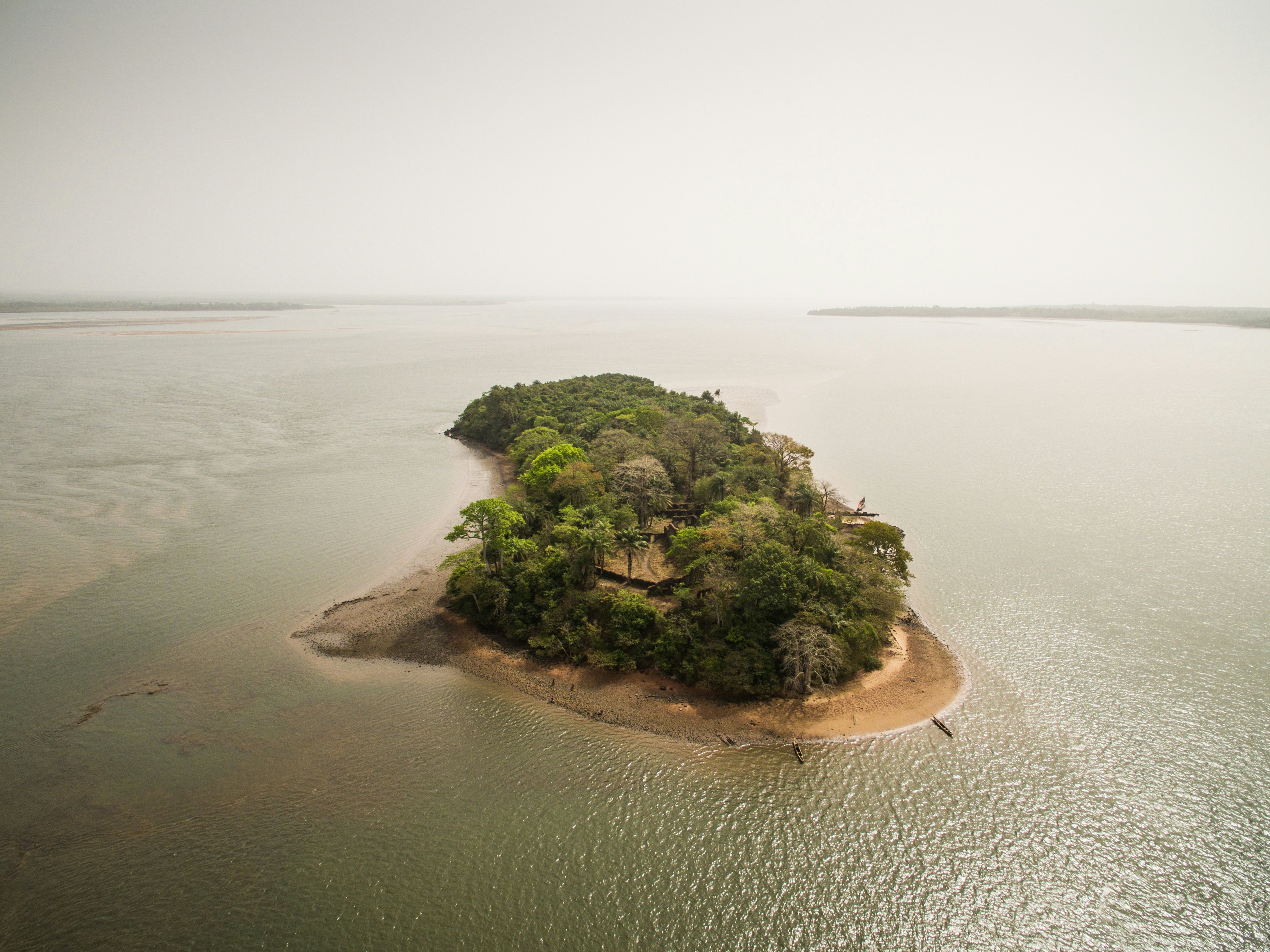 An aerial view of a small island in a wide river.